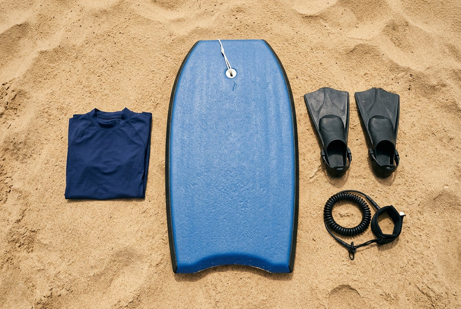 Pack de bodyboard principiante: tabla, aletas, leash y licra sobre la arena