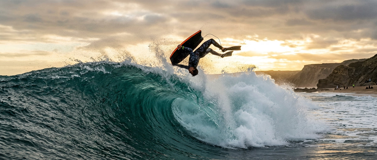 Bodyboarder in the middle of an el rollo above the lip of a wave