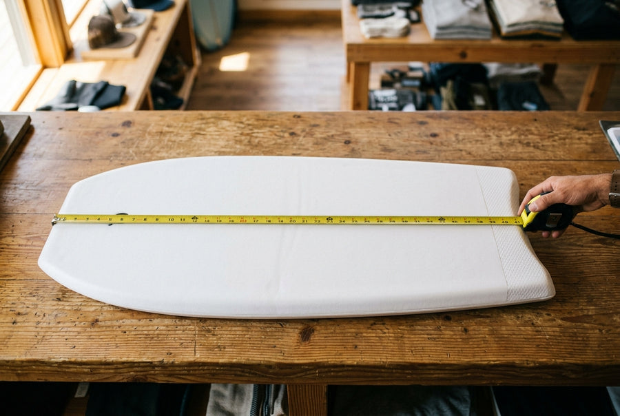 Mètre ruban déroulé sur la longueur d'une planche de bodyboard