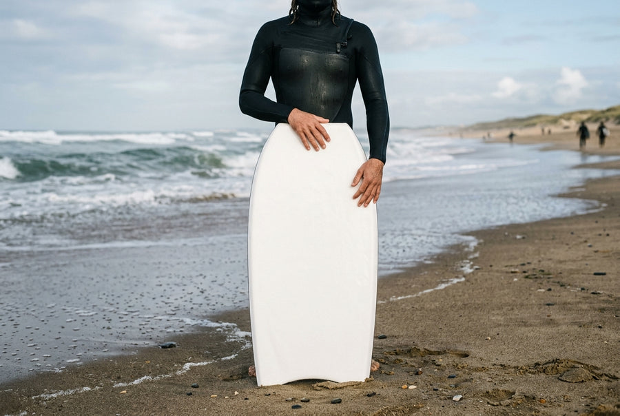 Planche de bodyboard posée à la verticale devant un rider, le nose au niveau du nombril